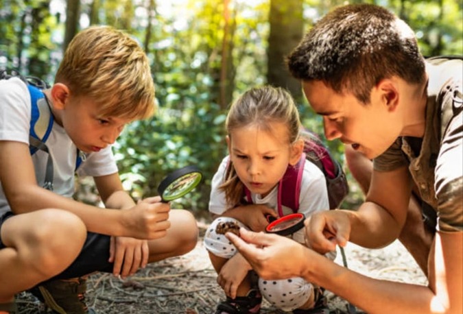 Copii explorând natura împreună cu un adult